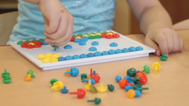 Pequeño niño juega un juego intelectual en una mesa — Vídeo de stock