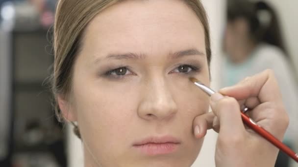 Maquillaje artista hacer maquillaje para modelo joven — Vídeo de stock