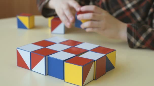 Um menino coletando um padrão usando cubos coloridos — Vídeo de Stock