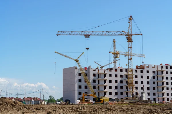 Construcción de un edificio de varios pisos. Las grúas funcionan Fotos de stock libres de derechos