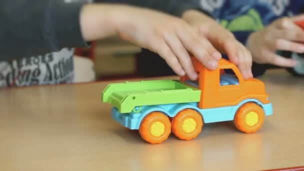 Kinderen spelen speelgoed, model auto's aan de tafel — Stockvideo