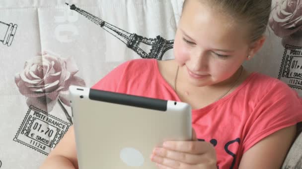 Ребенок читает цифровой планшет, лежащий на кровати — стоковое видео