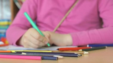 Çocuk resimleri defterini çizer.