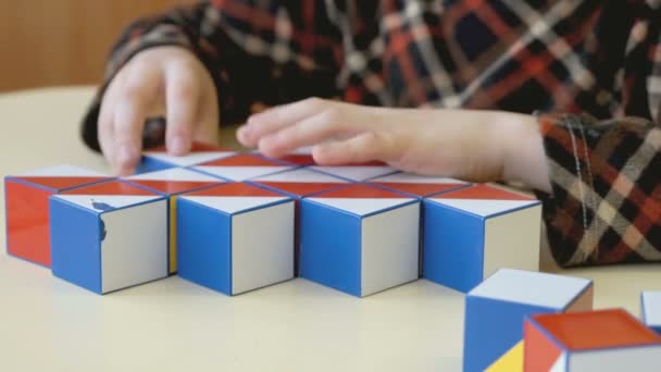Ребенок собирает шаблон с помощью цветных кубиков — стоковое видео