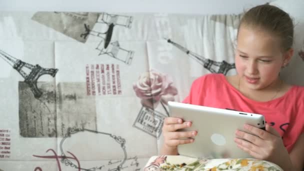 Дівчина-підліток використовує цифровий планшет на ліжку — стокове відео