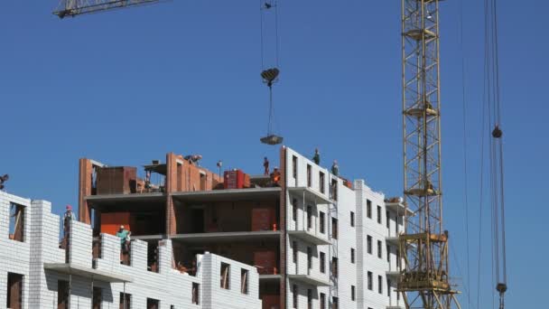 Будівельний кран поставляє цемент для будівельників — стокове відео