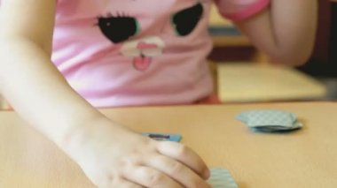 Küçük bir kız oyun kartları masaya çalış.