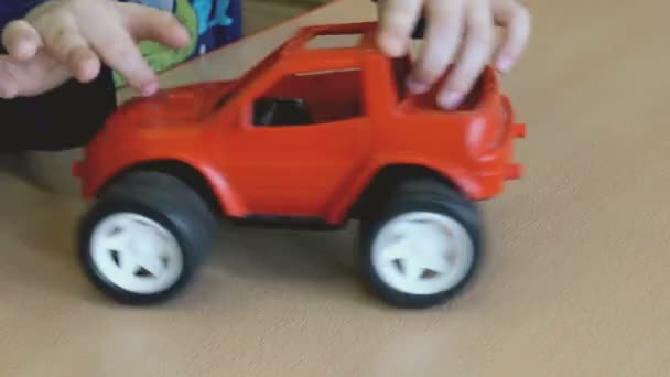 Два мальчика играют в игрушечные модели автомобилей за столом — стоковое видео