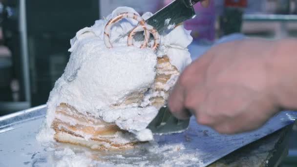 La mano corta un pastel de boda en pedazos en la boda — Vídeos de Stock