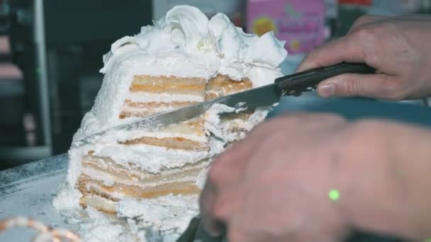 Mão corta um bolo de casamento em pedaços no casamento — Vídeo de Stock