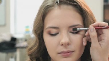 Genç manken için makyaj yapma makyaj sanatçısı