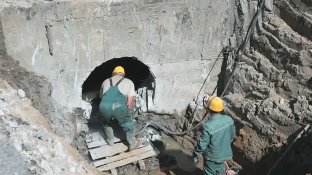 Dos trabajadores reparando un colector al aire libre — Vídeos de Stock