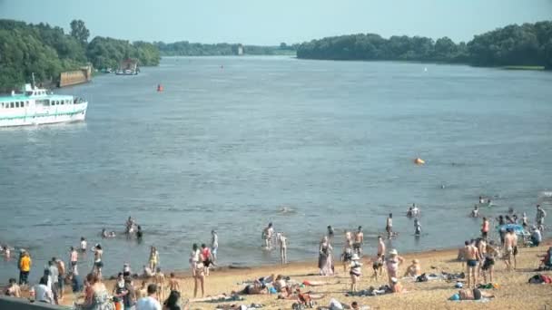 Mensen zwemmen en zonnebaden op het zandstrand — Stockvideo