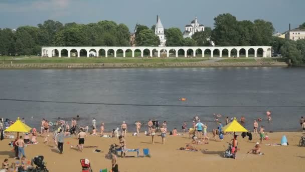 Люди плавают на переполненном песчаном пляже — стоковое видео