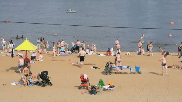 Gente tomando el sol en la playa llena de arena — Vídeo de stock