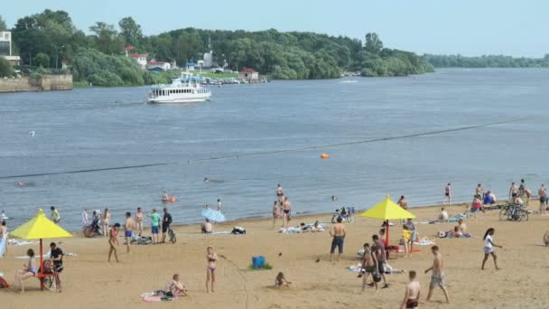 Mensen zwemmen en zonnebaden op het zandstrand — Stockvideo