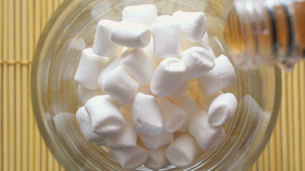 Pluizige witte marshmallows in de glas-cup — Stockvideo