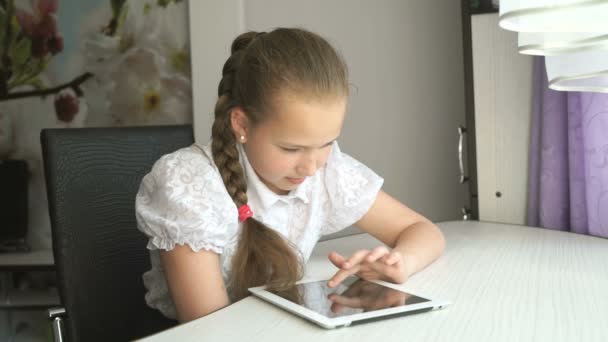 Školačka používá digitální tabletový počítač doma