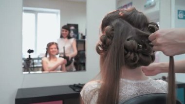 Profesyonel stilist bukleler için bir kız yapar.