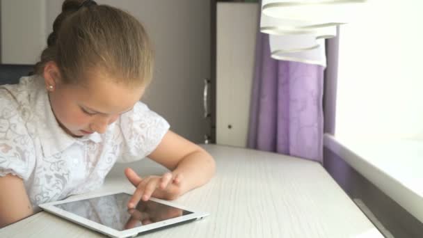 Menina bonito usa um computador tablet digital — Vídeo de Stock