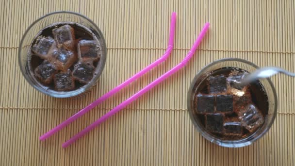 Human hand stirring spoon a glass of cola with ice — Stock Video