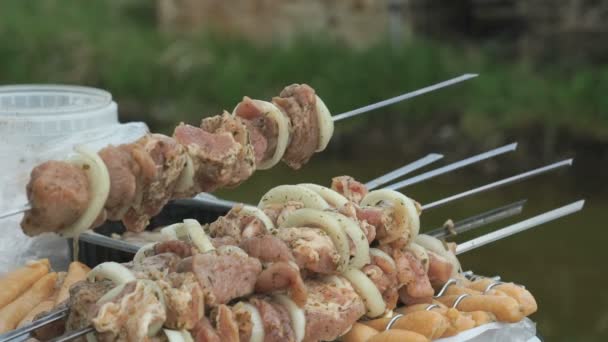 Humans hand strung pieces of raw meat on a skewer — Stock Video