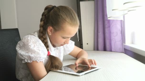 Adolescente menina usa um tablet digital na mesa — Vídeo de Stock