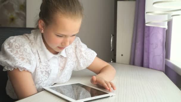 Linda niña utiliza una tableta digital — Vídeo de stock