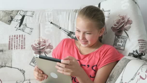 Kind liest auf dem Bett liegendes digitales Tablet — Stockvideo