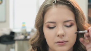 Genç manken için makyaj yapma makyaj sanatçısı