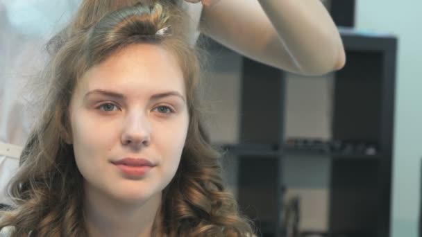 Peluquería peinando el cabello de una hermosa modelo — Vídeo de stock