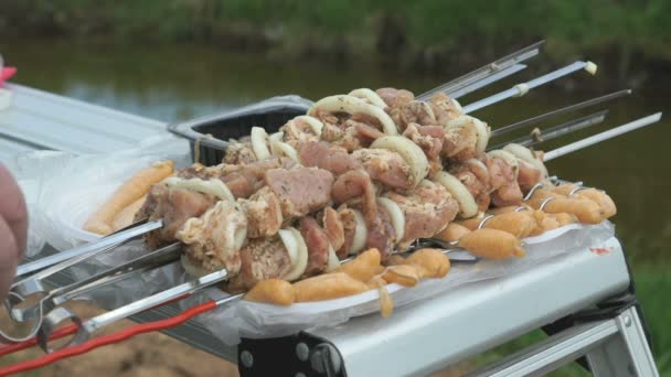 Man takes a skewers with fresh meat for roasting — Stock Video