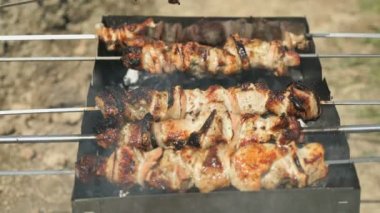 Açık havada kömürlerin üzerinde metal şiş üzerinde et hazırlar