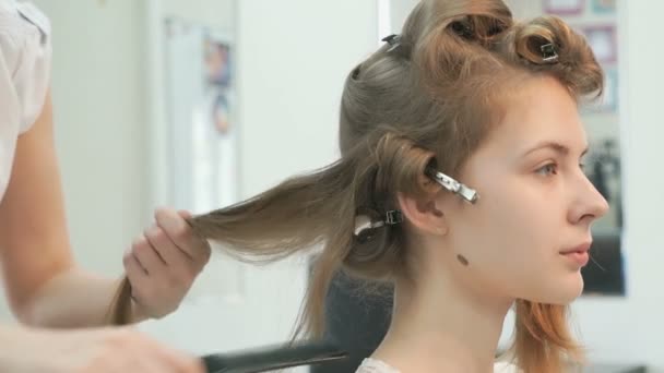 Master maakt de krullen aan meisje in de schoonheidssalon — Stockvideo