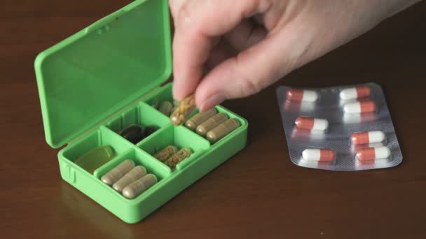 Dames hand zet capsules pillen in container — Stockvideo