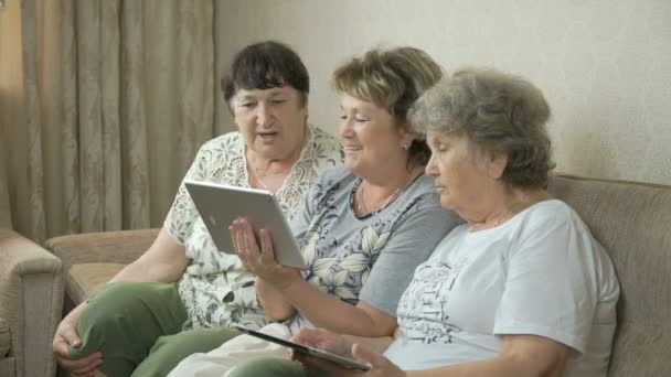 Grootmoeders kijken naar foto's met behulp van digitale tabletten — Stockvideo