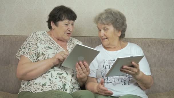 Zwei ältere Frauen halten die digitalen Tablets in der Hand — Stockvideo