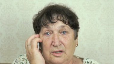 Cep telefonu kullanan yaşlı bir kadın.