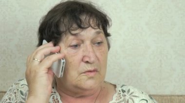 Cep telefonu kullanan yaşlı bir kadın.