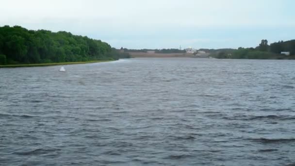 Witte boei drijvend in de rivier naast de kust — Stockvideo