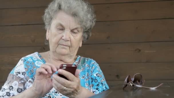 Gammal kvinna med en smartphone — Stockvideo