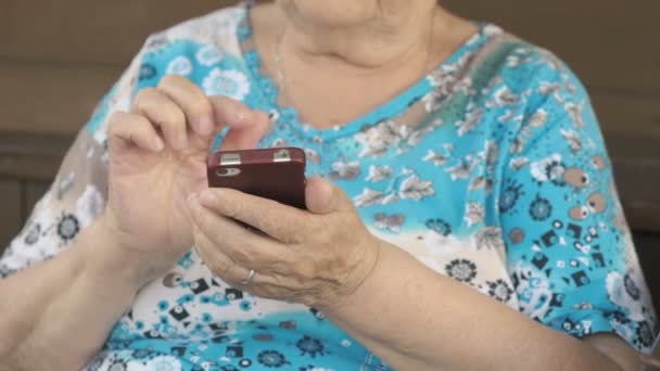 Mulher idosa segurando um telefone celular — Vídeo de Stock