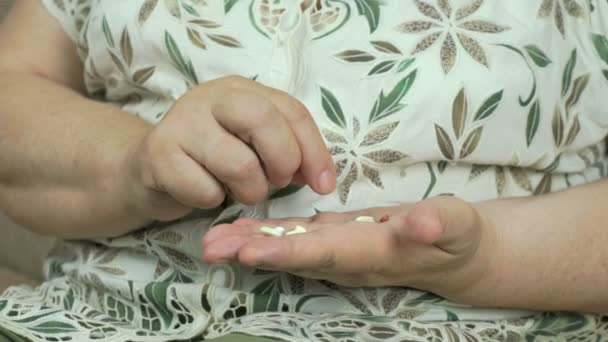Vecchia donna considera pillole sul palmo della mano — Video Stock