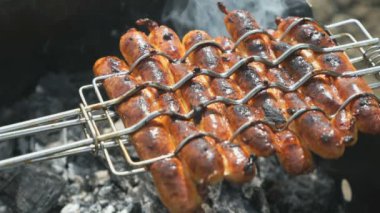 Sıcak parlayan kömürler üzerinde ızgara sosis