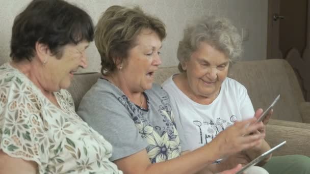 Äldre kvinnor innehar digital tabletter hemma — Stockvideo