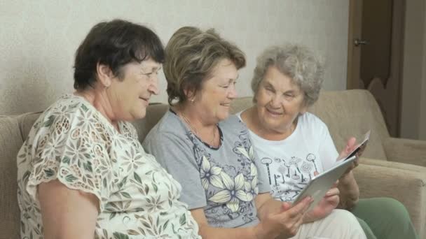 Oudere vrouwen kijken naar foto's op scherm van tabletten — Stockvideo