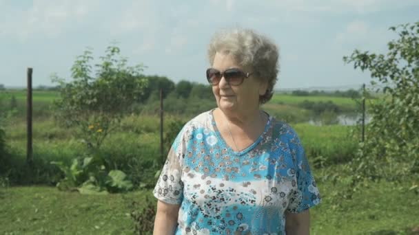 Oude vrouw lopen in het park van de tuin — Stockvideo