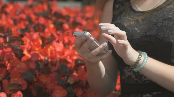 Ung flicka håller en mobil och läser meddelanden — Stockvideo