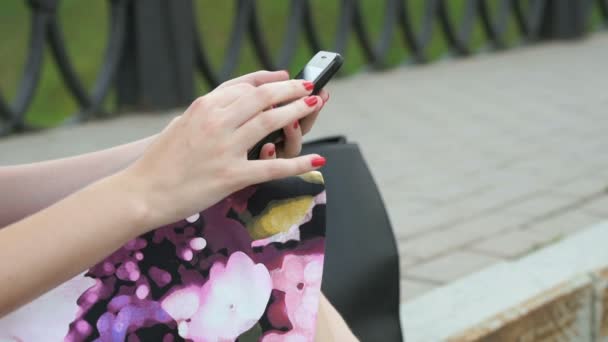 Chica joven sostiene un teléfono celular y lee mensajes — Vídeo de stock