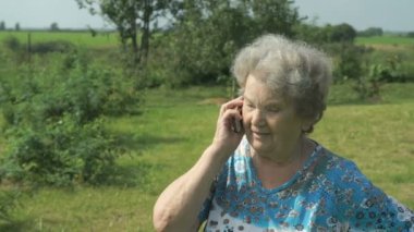 Yaşlı kadın 80s cep telefonunda söyler